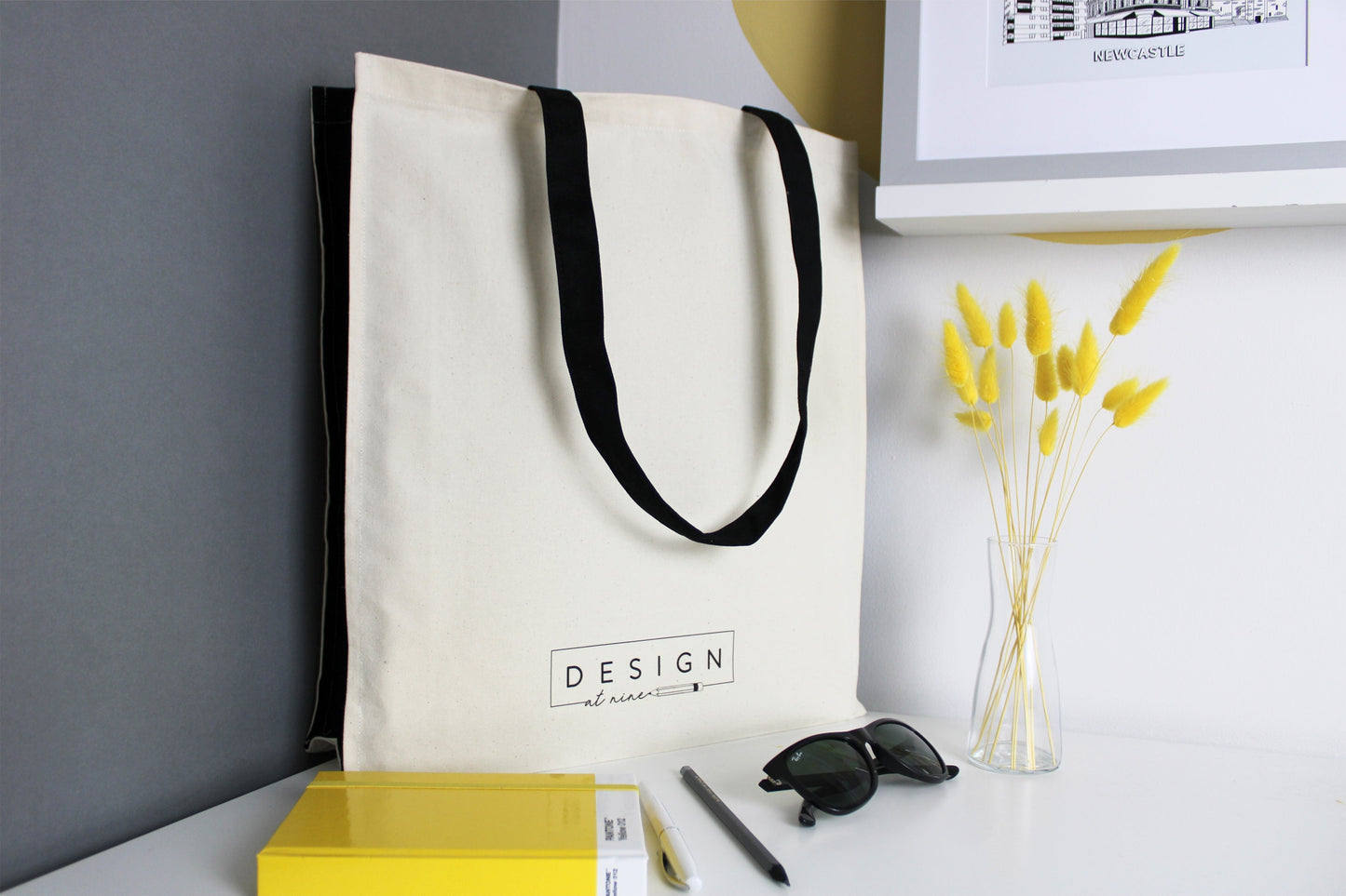 Nottingham illustration featuring all the well known buildings and landmarks of the city on a 100% cotton canvas tote bag with black straps and side panels. The back of the bag feature the Design at Nine logo at the bottom.