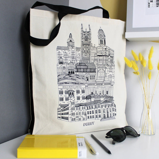 Derby illustration featuring all the well known buildings and landmarks of the city on a 100% cotton canvas tote bag with black straps and side panels. The back of the bag feature the Design at Nine logo at the bottom.